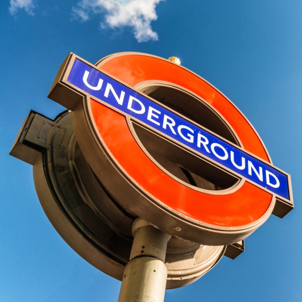 Close-up of a London Underground sign with directions to Penile Papules Clinic, helpful for patient navigation.