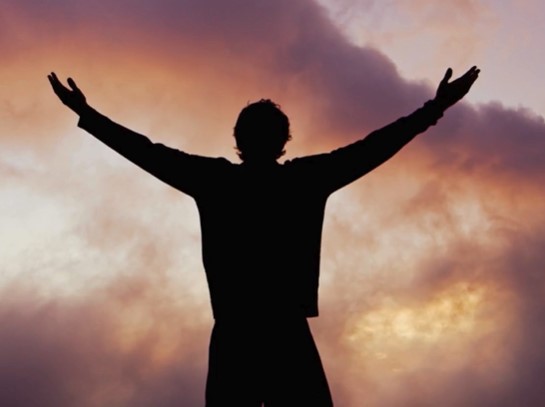 Man expressing freedom and relief outdoors, arms spread wide, post-Pearly Penile Papules removal treatment.